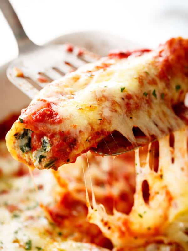 A spatula holding Spinach Cheese Manicotti