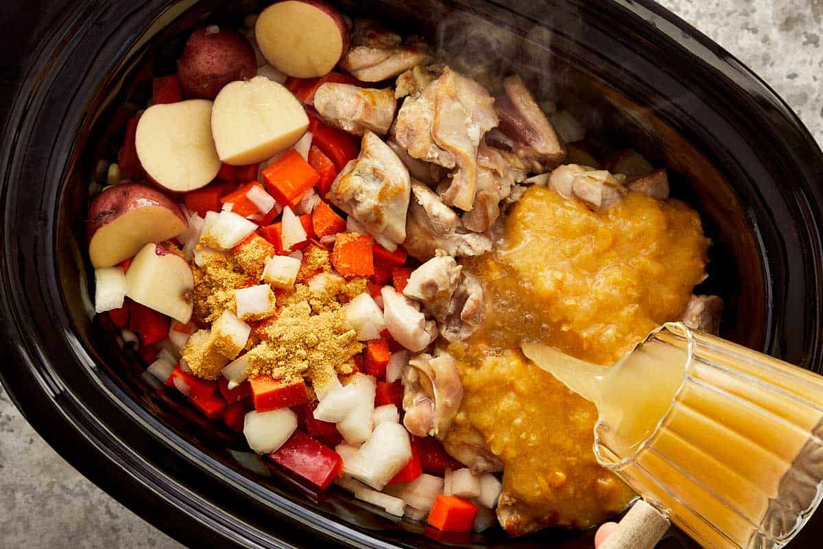 Chicken, potatoes, corn and vegetables added to the slow cooker for chicken bacon corn chowder.