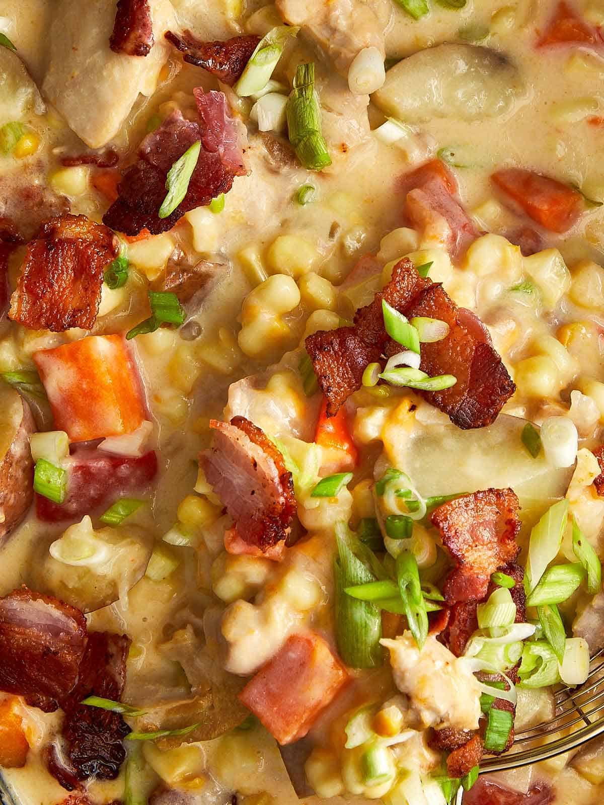 Close up of creamy slow cooker chicken bacon corn chowder with potatoes, sweet corn, crispy bacon and green onions.