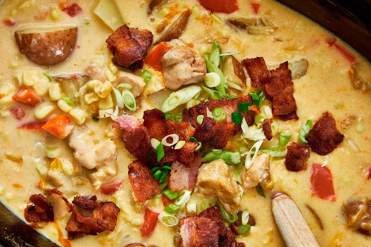 Creamy slow cooker chicken bacon corn chowder topped with crispy bacon and green onions.