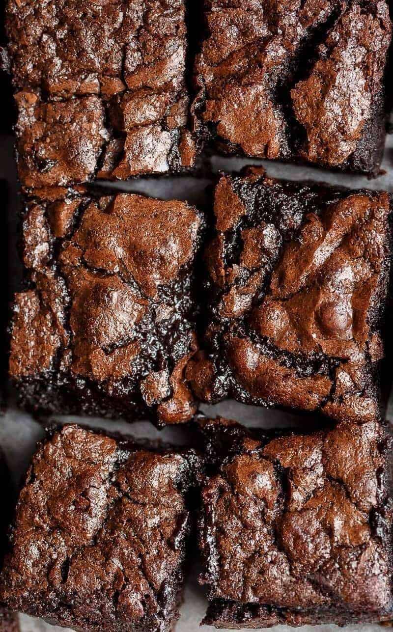 Bird's eye view of six of Fudgy Cocoa Brownies on baking paper.