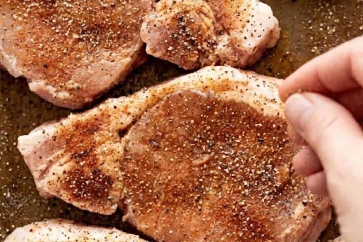 Pat the pork chops dry, then rub with salt, pepper, garlic powder, onion powder, and paprika.