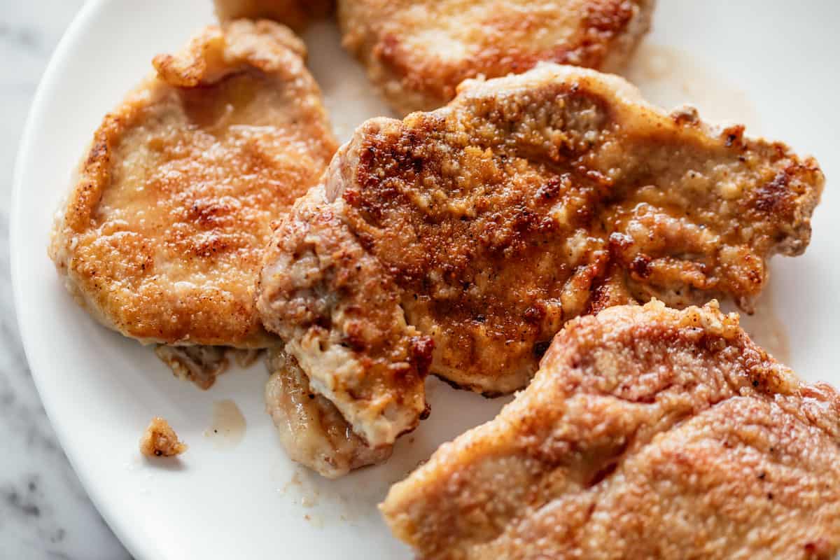 image of Breaded, seared bone-less pork chops on a white plate.