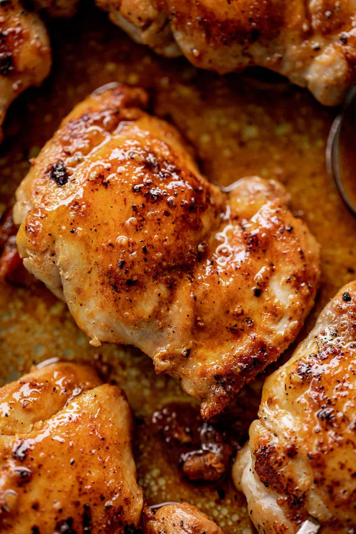 Close-up image of boneless chicken thighs, browned in butter and crispy, in a rich sauce.