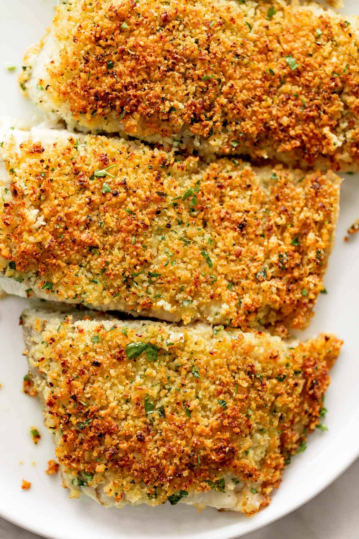 3 pieces of Garlic Parmesan Crumbed Fish on a plate. 