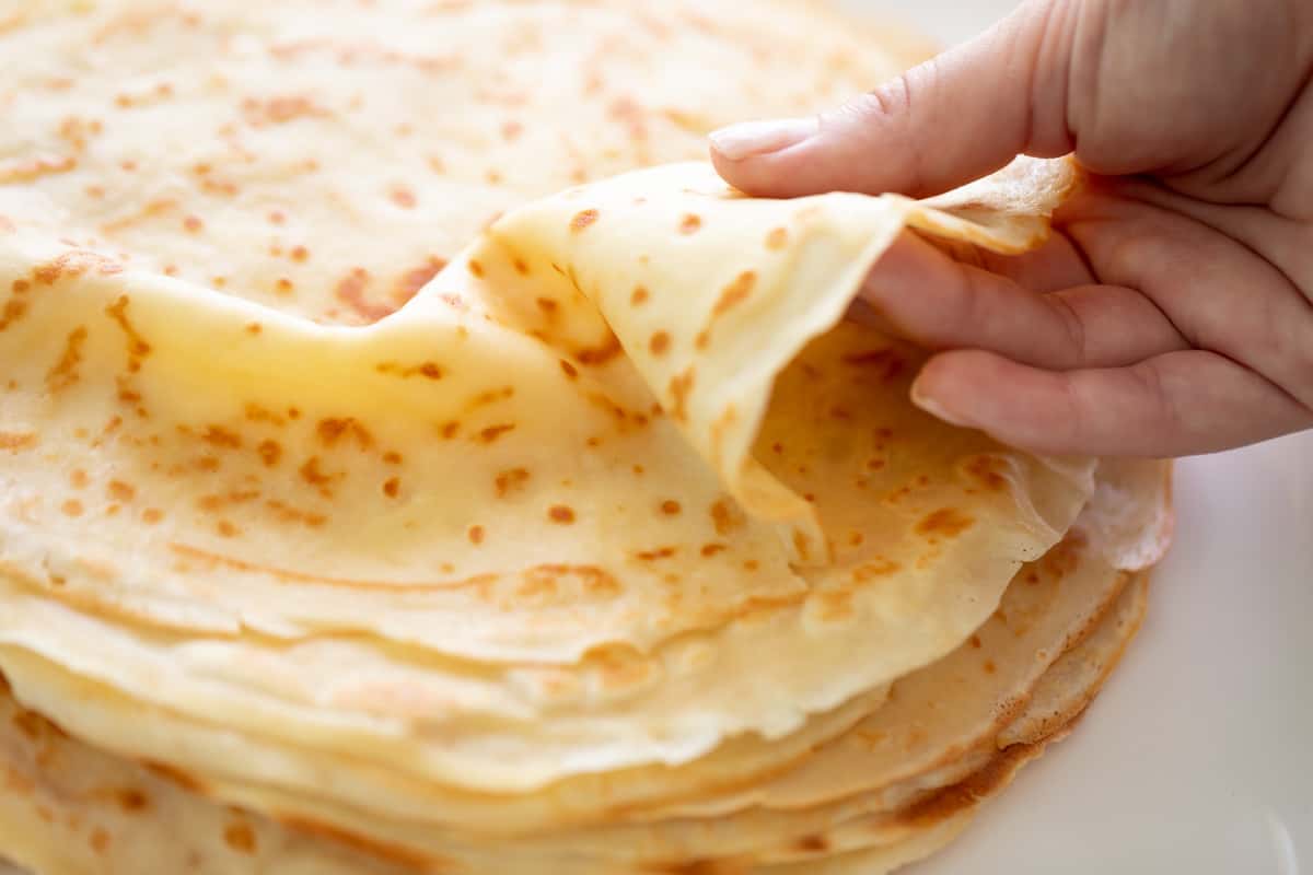 Holding a crepe from the top of a stack.
