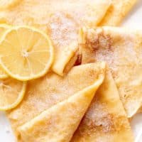 3 crepes with lemon slices and caster sugar