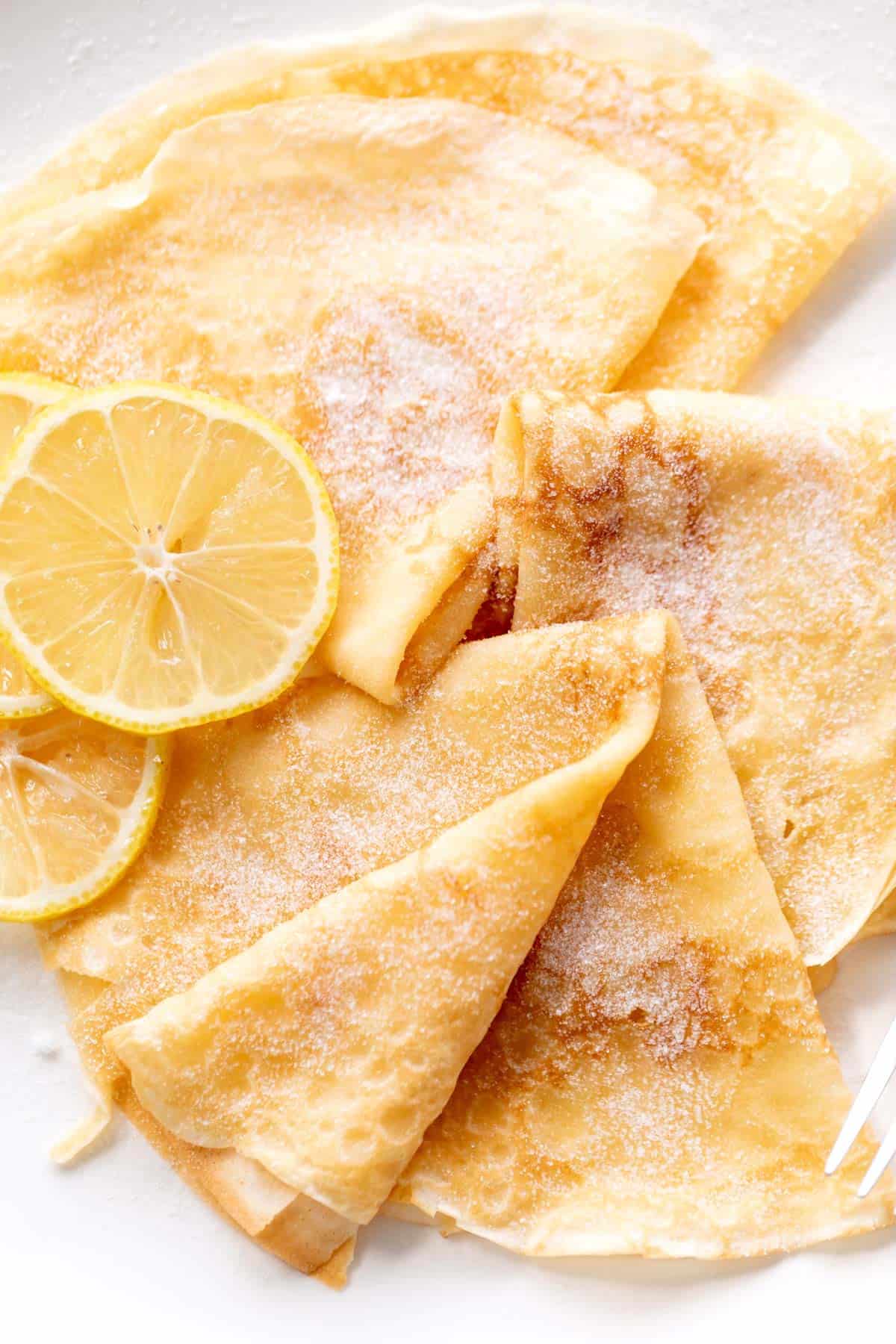 3 crepes with lemon slices and caster sugar