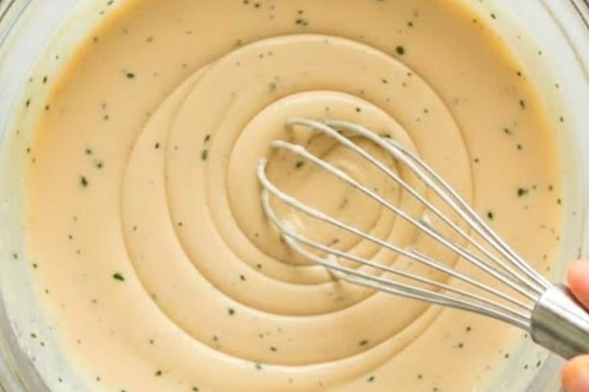 In a separate bowl, combine mayonnaise, sour cream, vinegar, mustard, herbs, sugar, garlic, salt, and pepper.