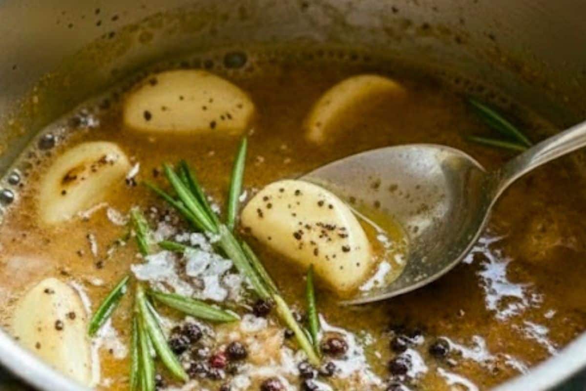Add smashed garlic cloves, herb sprigs, salt, and pepper. Stir gently to brown the garlic and lift any flavorful browned bits from the pan.
