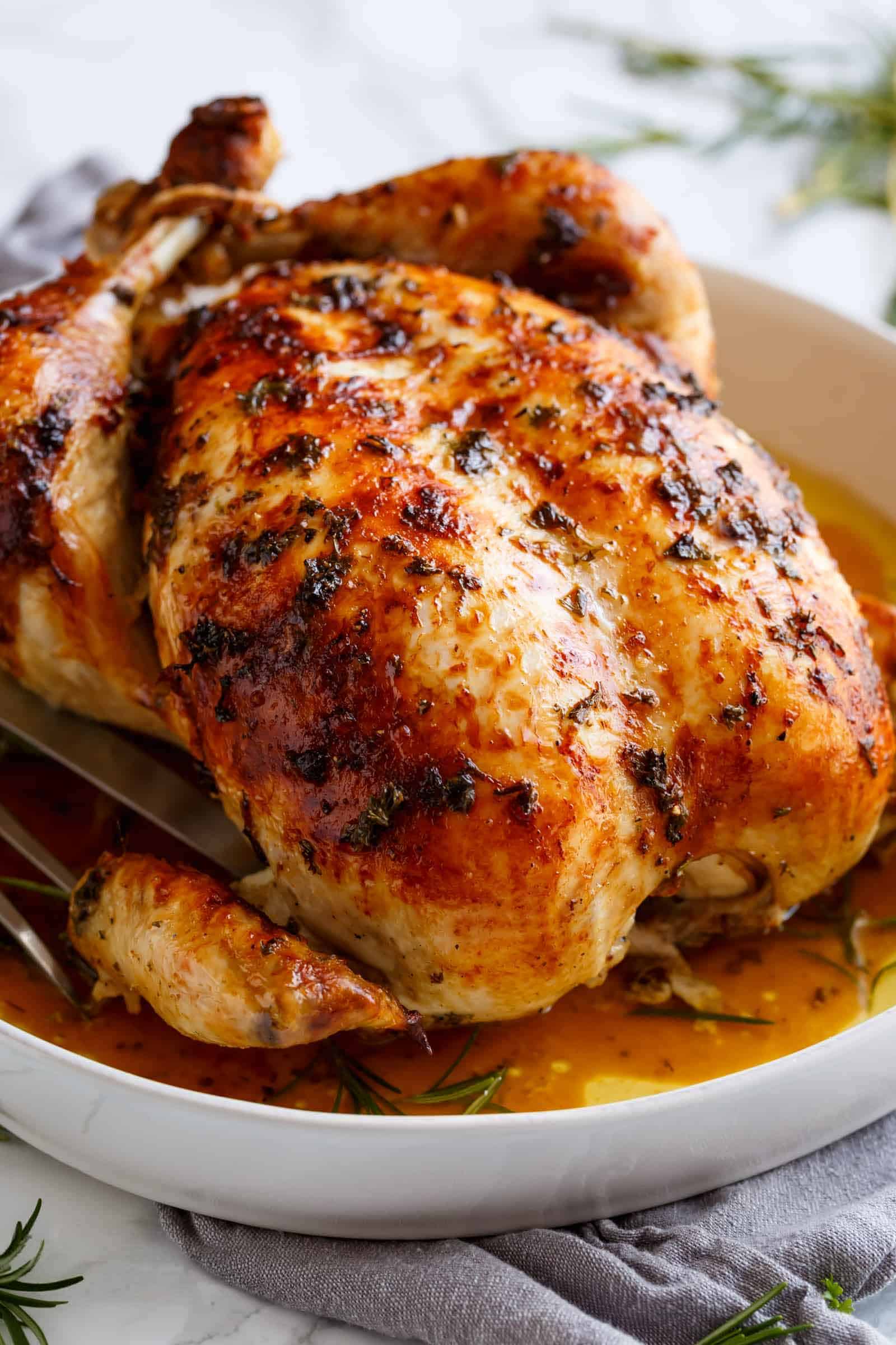 Image of the garlic roast chicken being taken out of the oven and sliced to reveal its tenderness and juiciness.