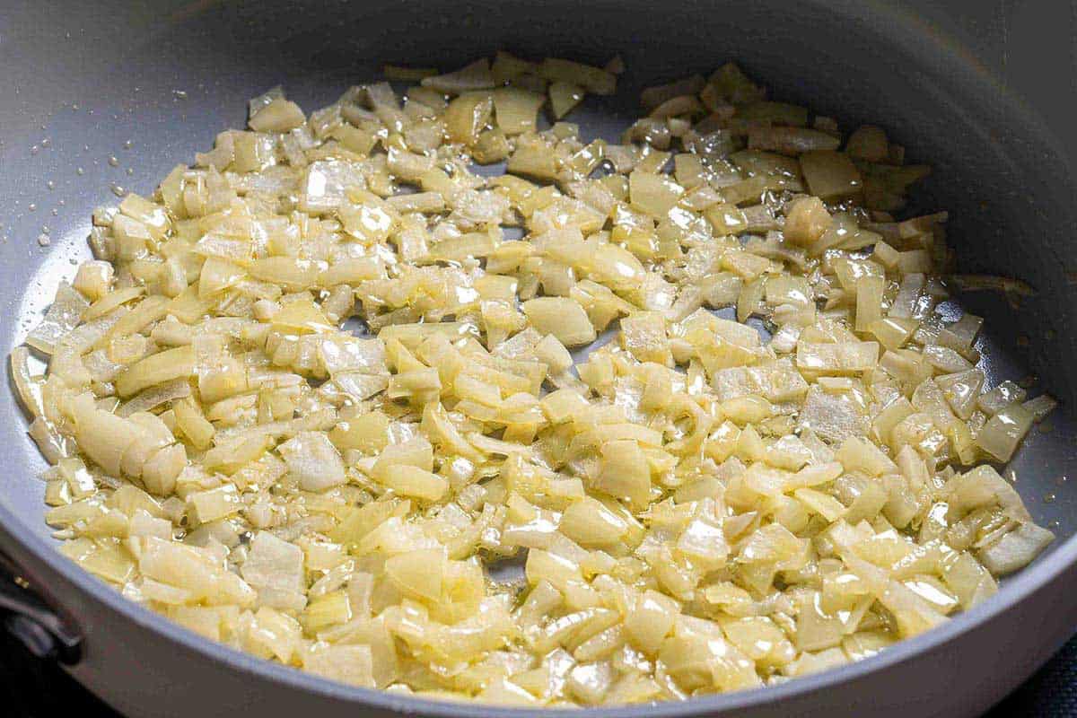 diced onions being sautéd in a pan