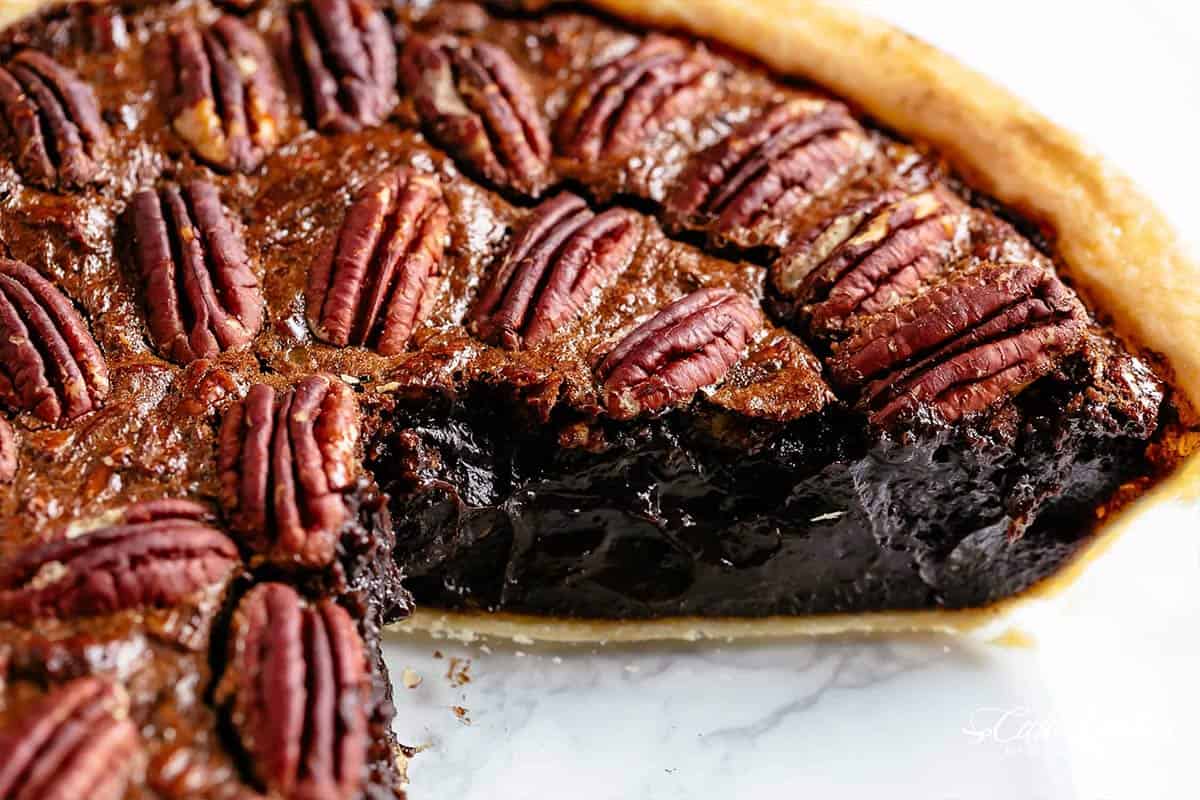 brown chocolate pecan pie cut down the middle with a rich moist centre