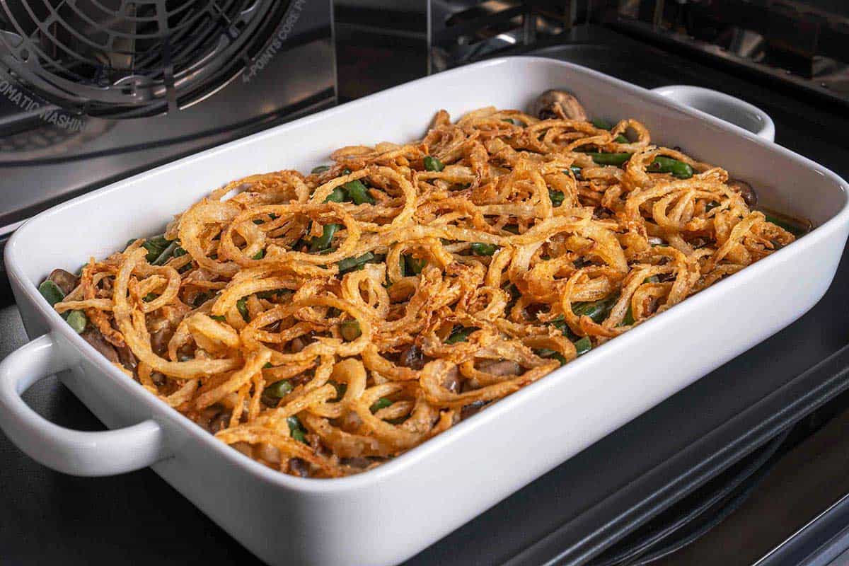 green bean casserole dish in oven with golden crispy fried onion rings on top