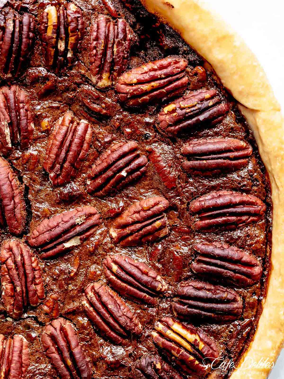 Close up image of a completed chocolate pecan pie with a golden crust.
