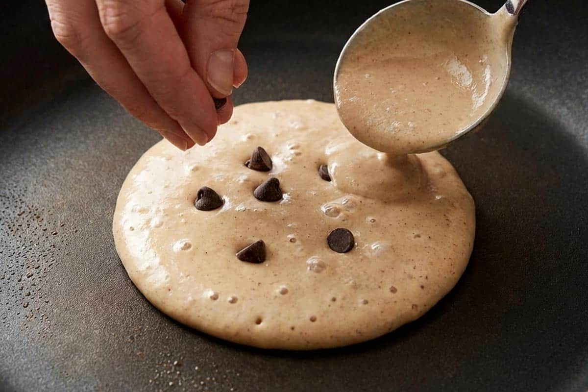 Cooking the batter and putting chocolate chips into the center.