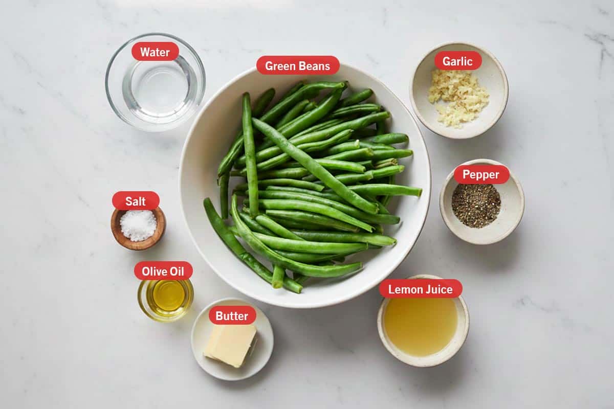 Top shot of ingredients: water, green beans, garlic, pepper, salt, olive oil, butter, and lemon juice.