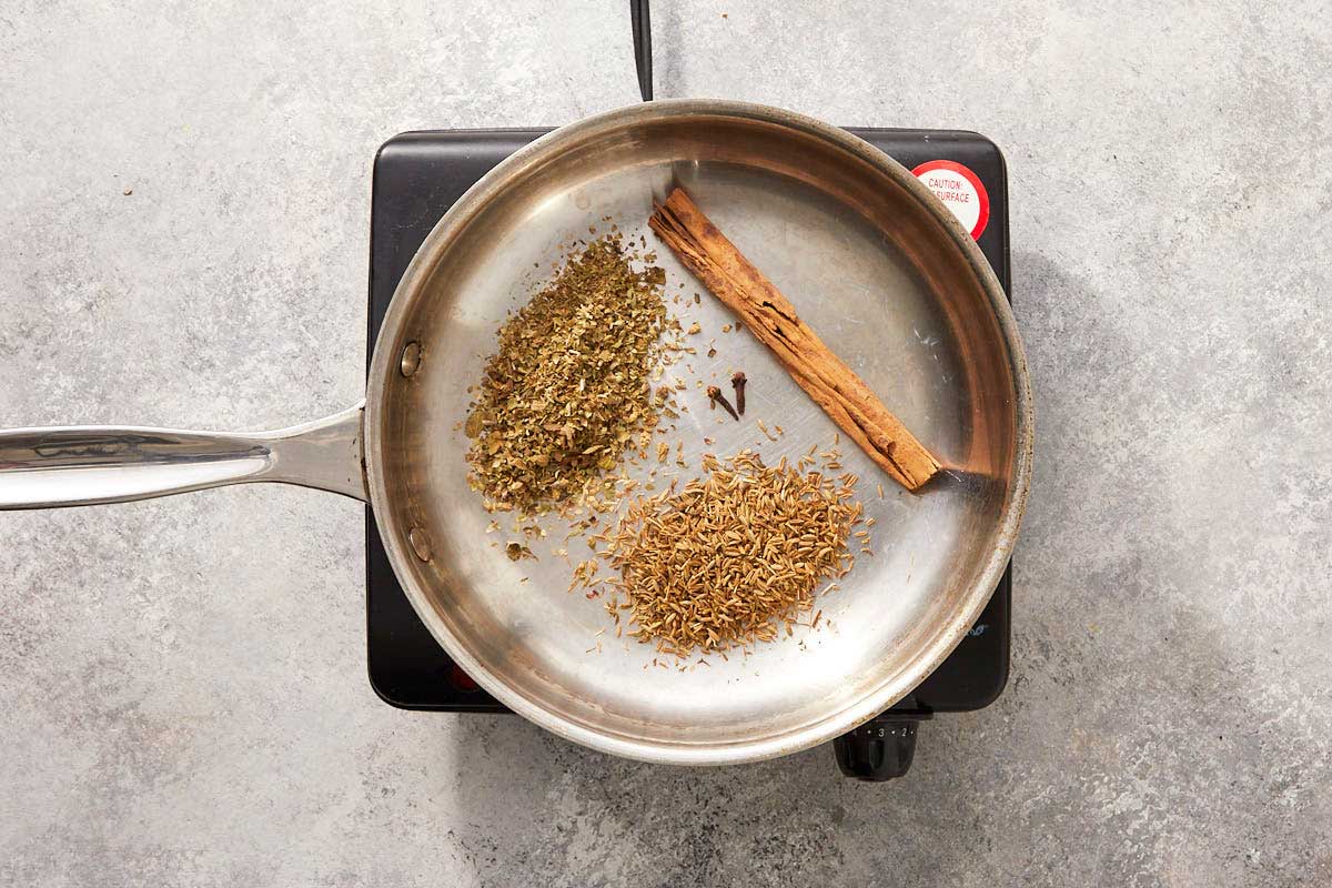 Dry spices toasting in a pan.