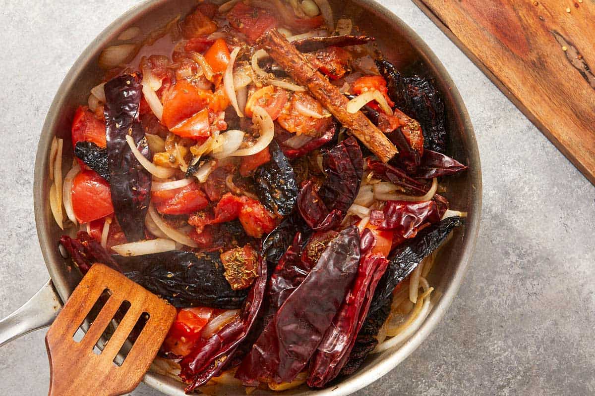 Sautéed onions and tomatoes in a pan.