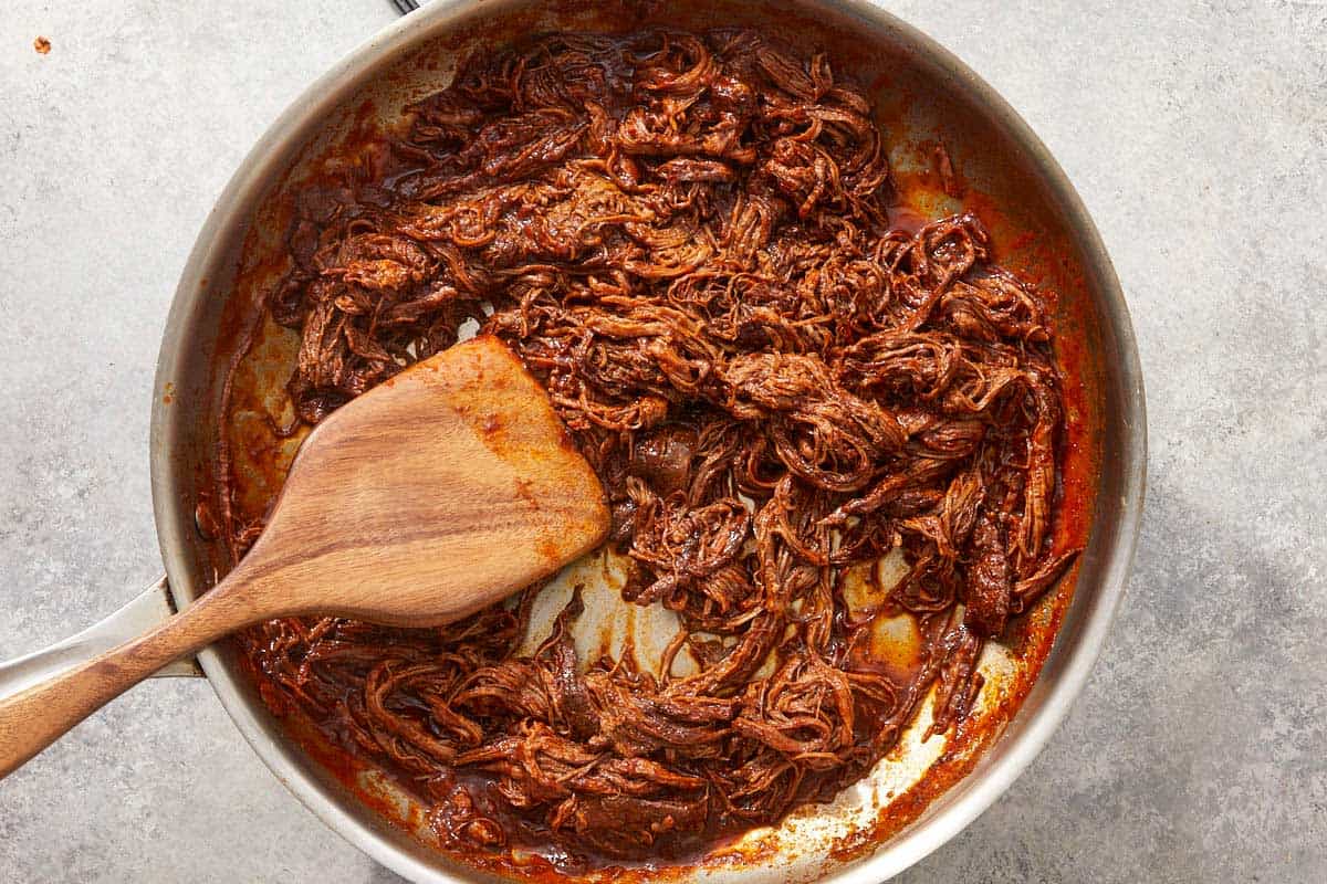 Shredded birria meat in skillet