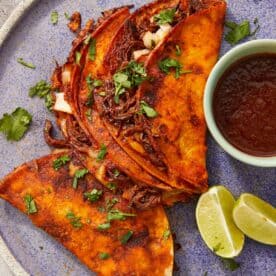 Crispy beef birria tacos with melty cheese and a rich red chile broth for dipping—bold, cheesy, and full of flavor.