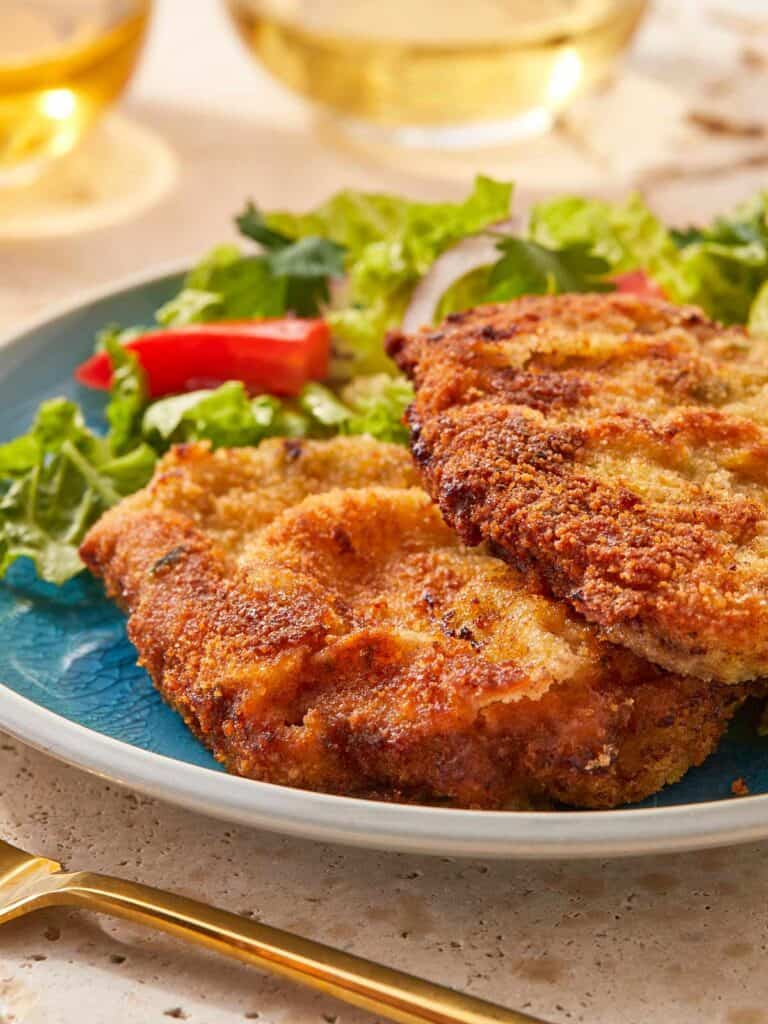Close-up of crispy beef milanesa served with salad.