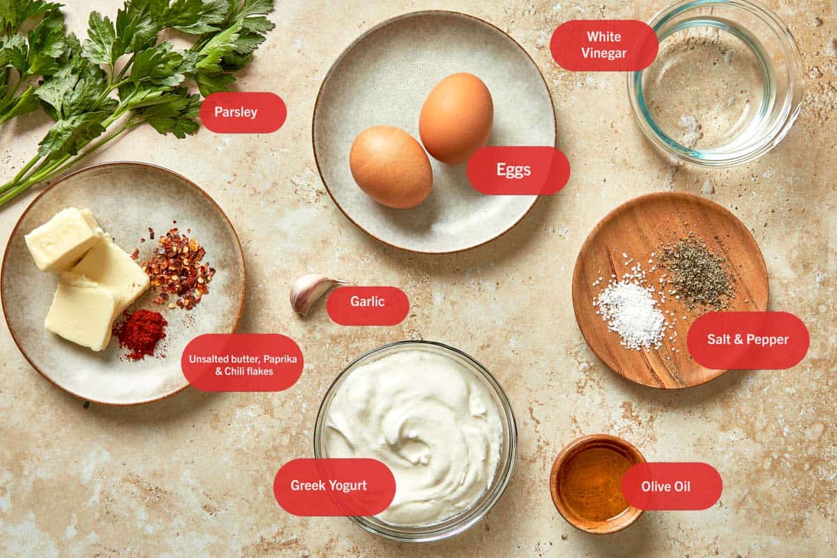 Ingredients for Cilbir, including Greek yogurt, eggs, garlic, butter, chili flakes, paprika, olive oil, vinegar, parsley, and seasoning.