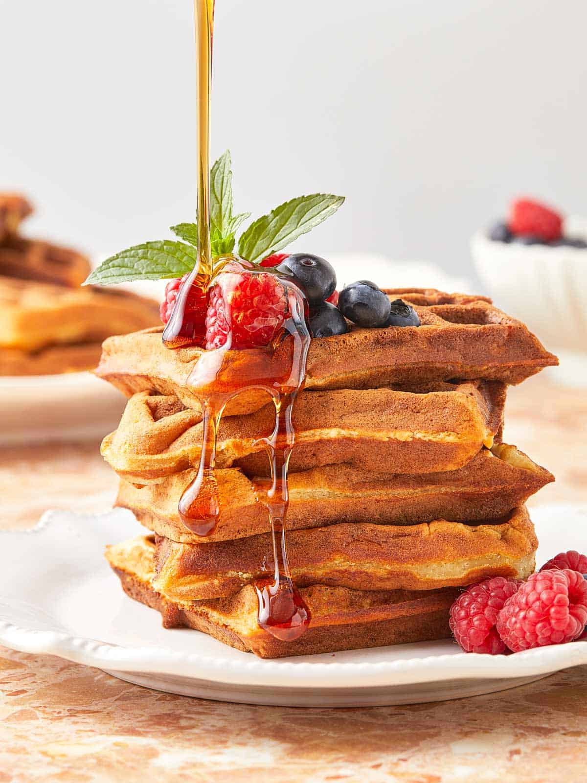 A stack of golden Wancakes with syrup cascading over them.
