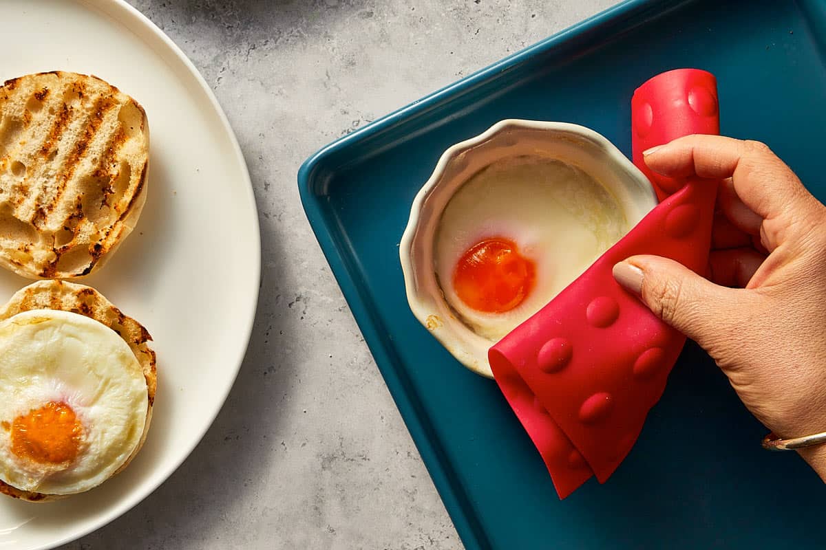 Hand removing poached egg from the airfryer