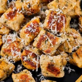 Close-up of golden gnocchi pieces with parmesan shavings.