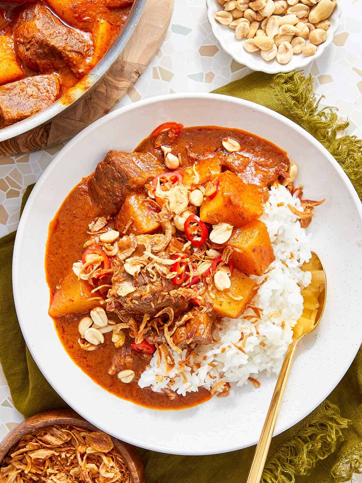 Massaman Beef Curry served over jasmine rice, topped with peanuts and crispy shallots.
