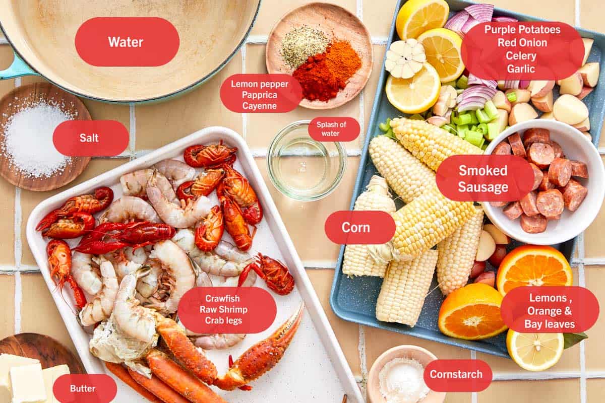 Ingredients for a seafood boil laid out on a tiled counter.