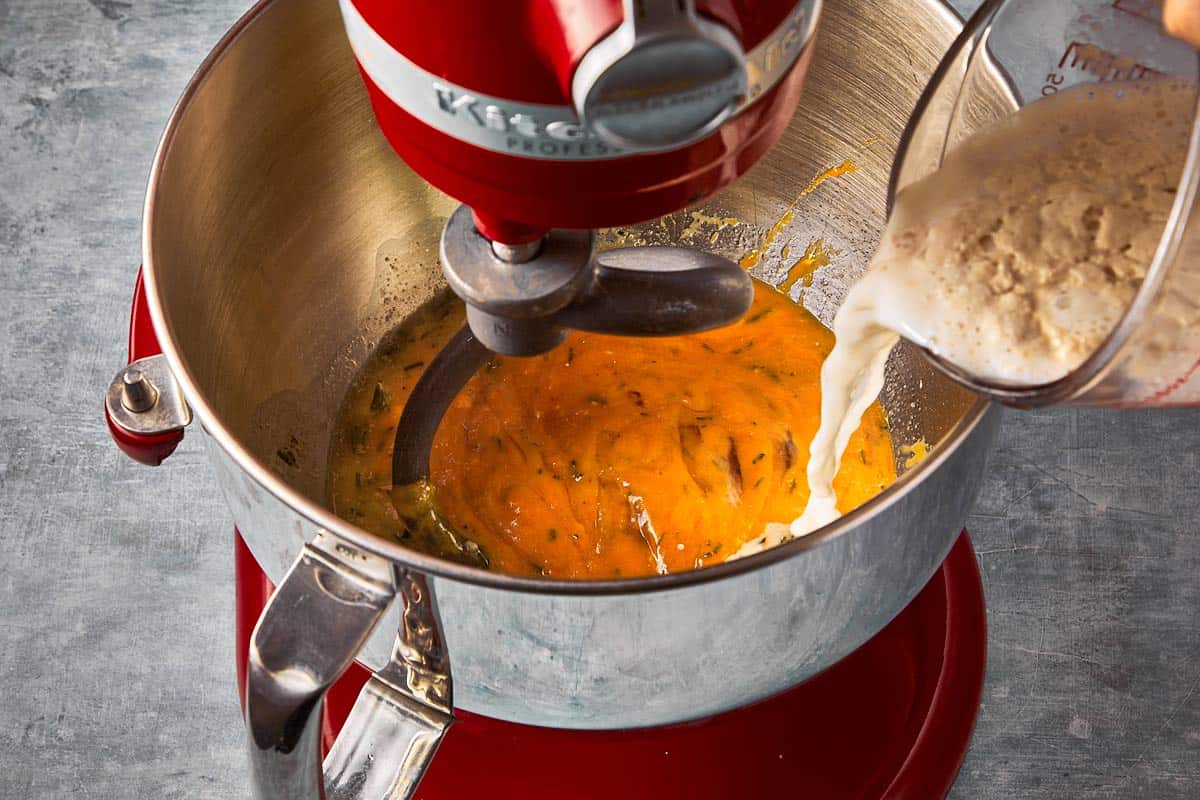 a stand mixer with a dough mix being poured into it