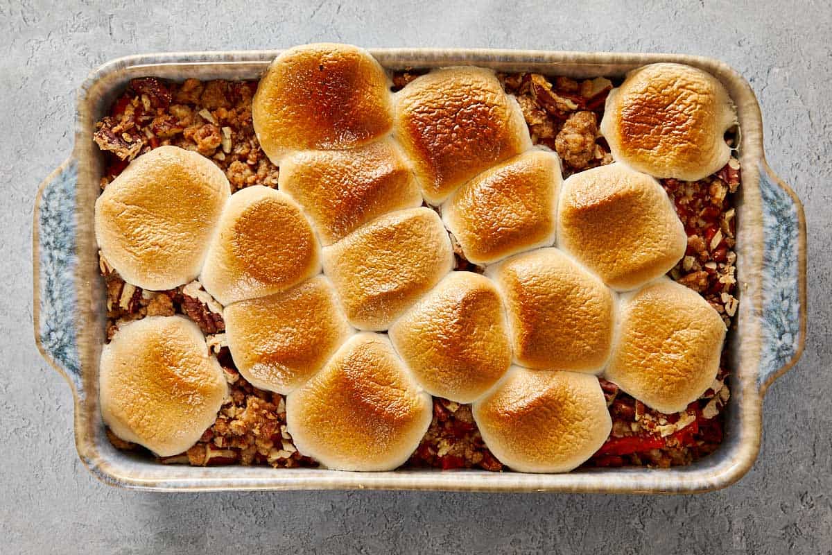 Sweet potato casserole in a baking dish topped with evenly toasted, golden marshmallows.