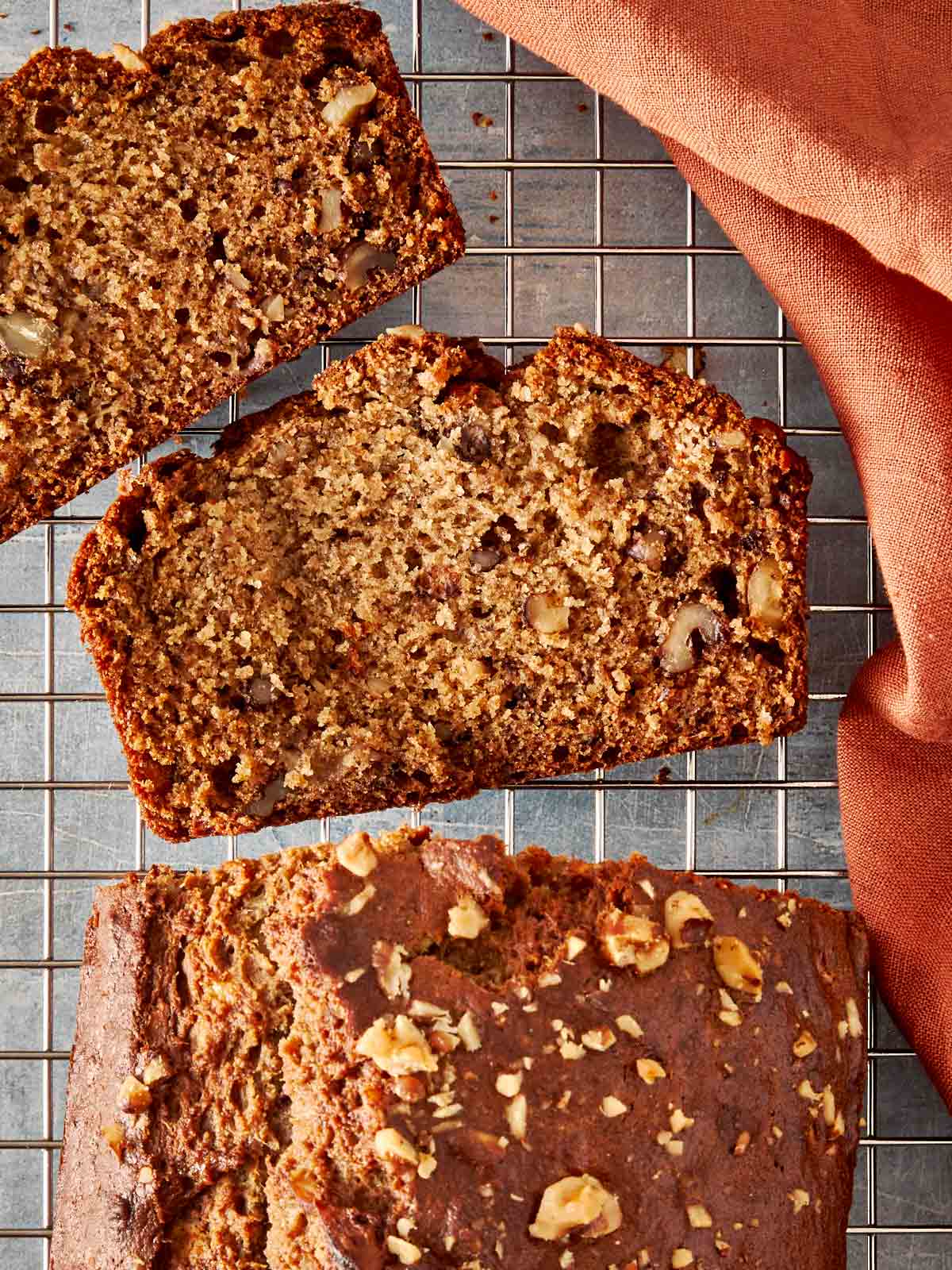 a top down view of slices of brown banana bread resting on a wire tray