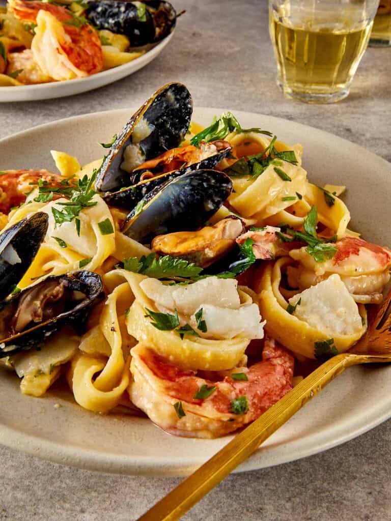a side view of a pasta and seafood dish that looks creamy
