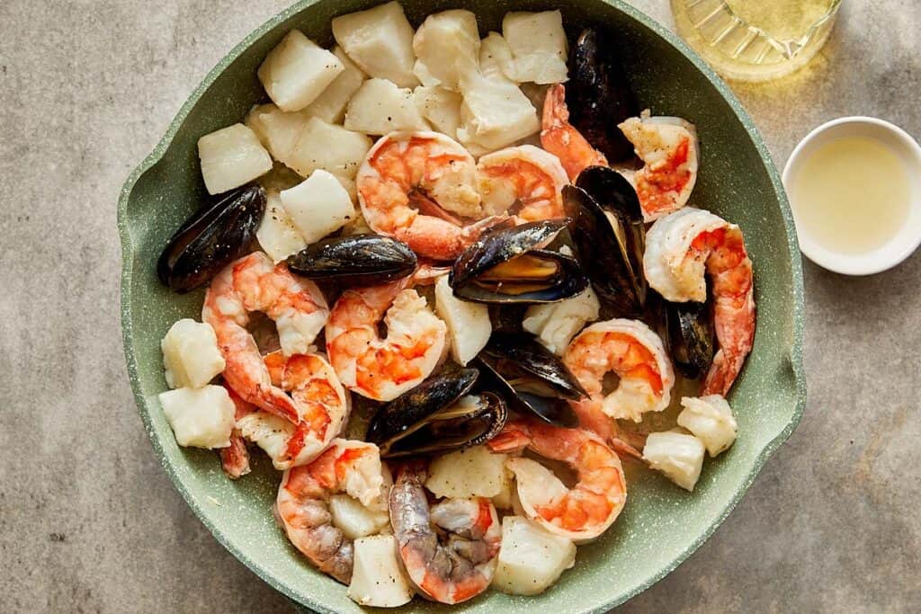 a top down view of a plate full of seafood an being cooked
