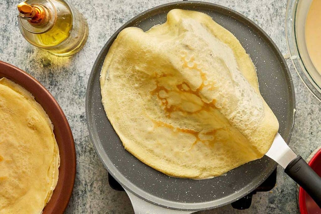 a top down view of a crepe being removed from a pan