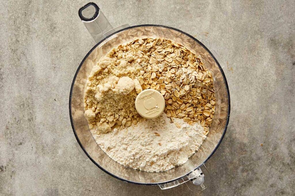 a top down photo of a food processor with dry ingredients in it ready for blending