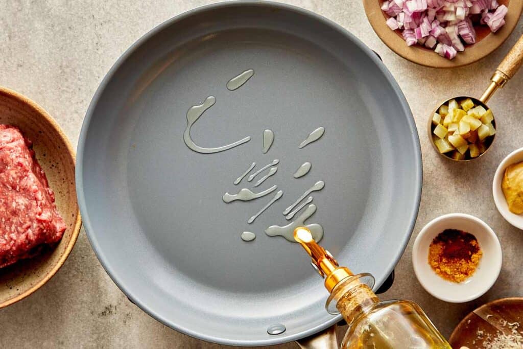 A top down view of a empty pan with olive oil being poured into it.