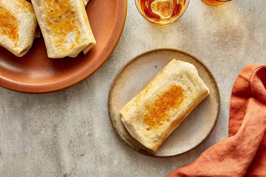 a top down view of a plate of wraps toasted and a single wrap toasted