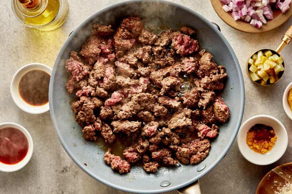 a top down view of a pan filled with mince meat being cooked on a benchtop stove