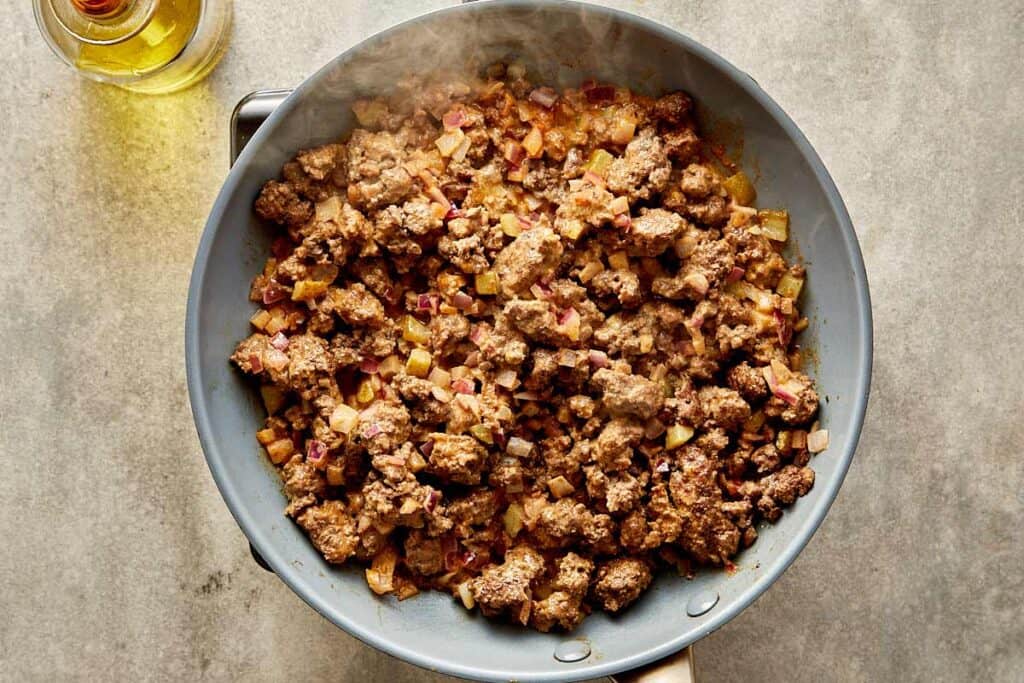 a top down view of a pan filled with mince meat being cooked on a benchtop stove