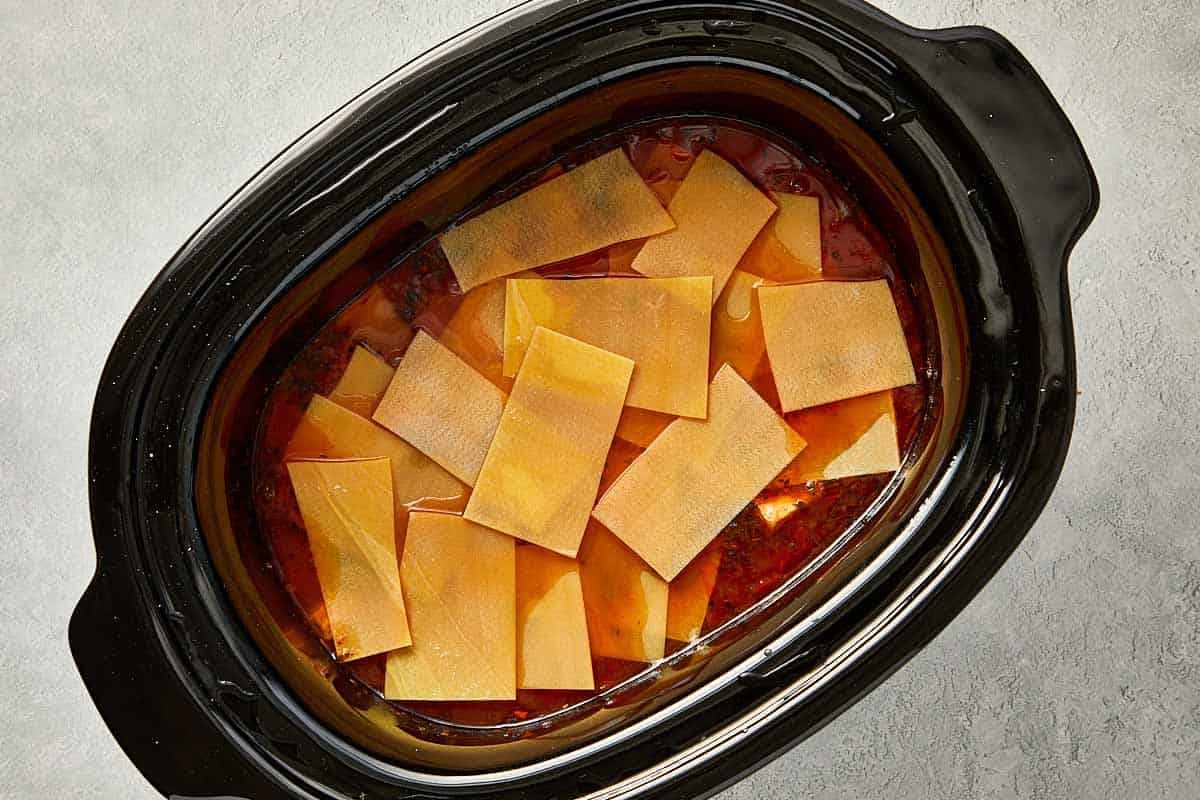 top overview of broke lasagna sheets pieces into the slowcooker