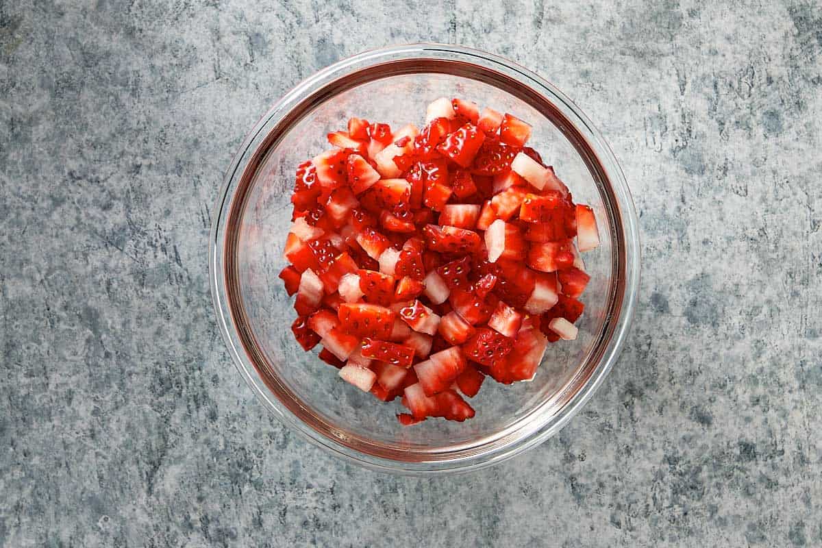 Top overview of finely chopped strawberries in a bowl.