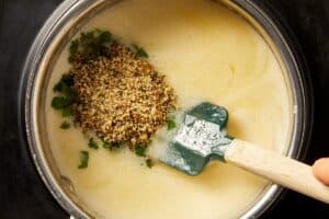 Adding lemon pepper seasoning, parsley, and aromatics to melted butter to make the lemon pepper sauce