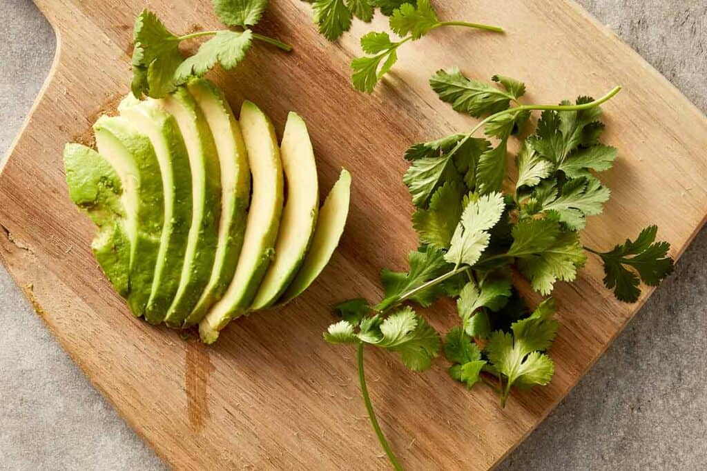 Top overview chopped avocado and coriander leaves.