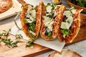 Chicken parm smashed tacos assembled with arugula and toppings