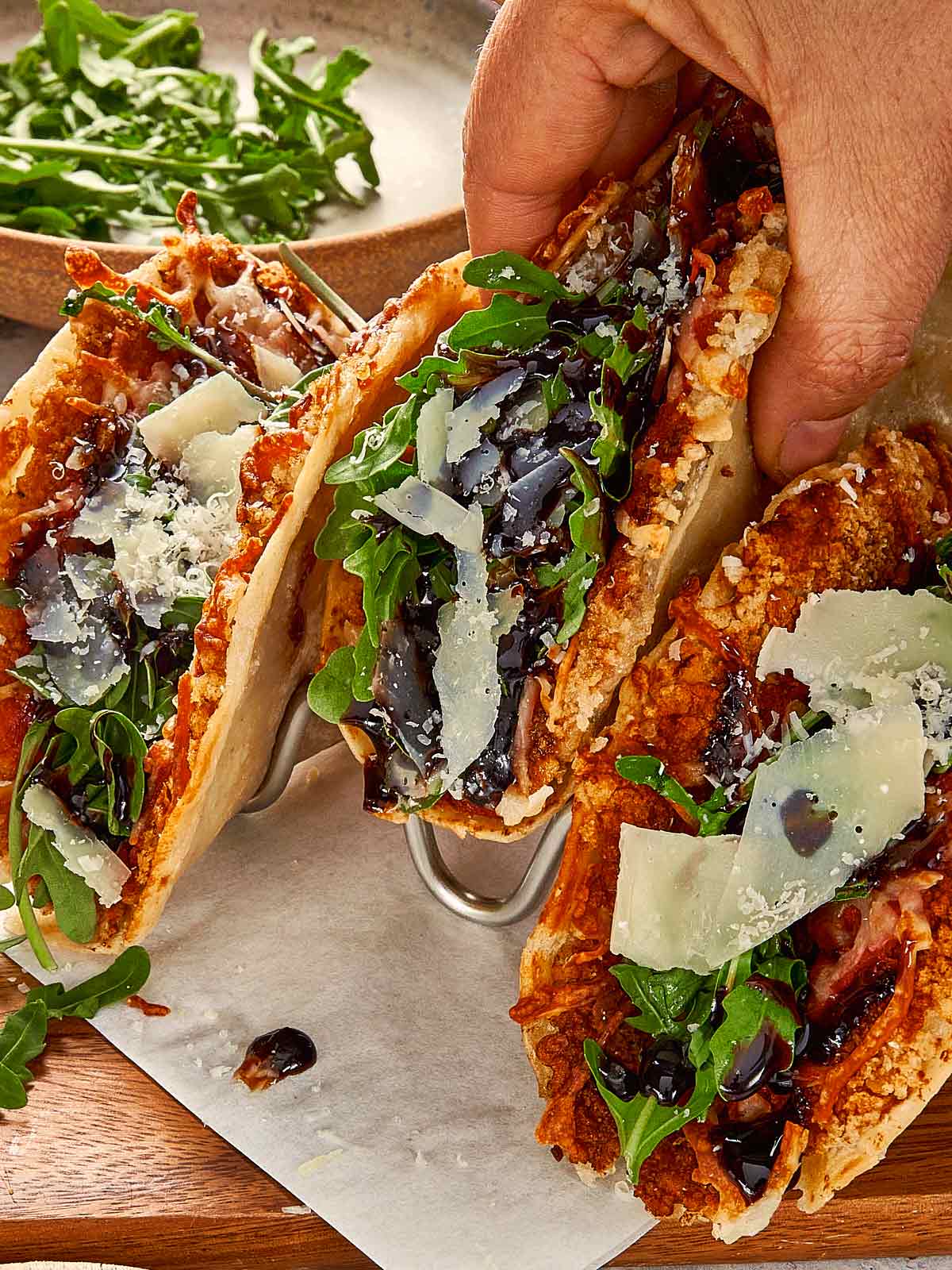 Hand holding a smashed parm chicken taco