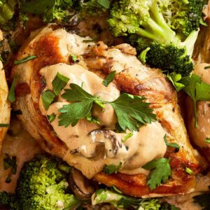 Close Up focusing on chicken pieces from Julia Child's Creamy Chicken + Mushroom in a pan
